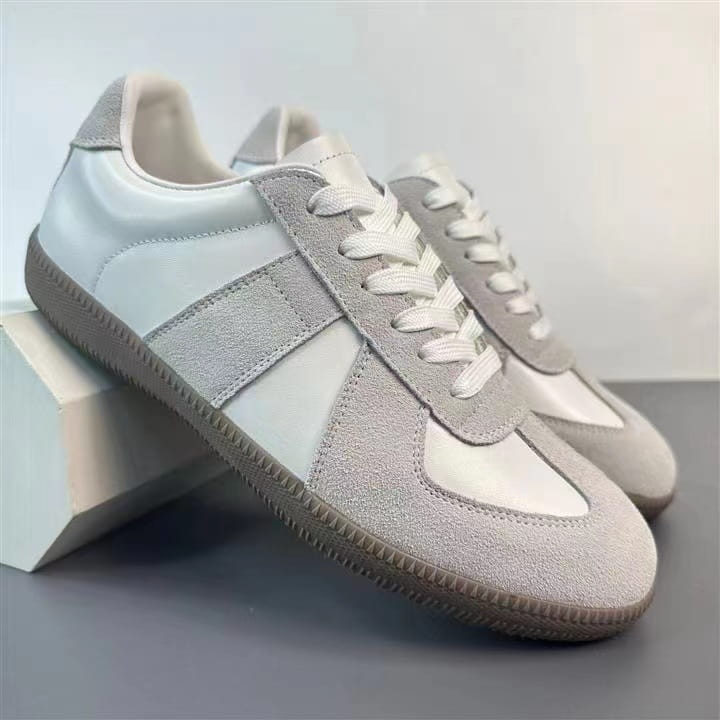 Hellgraue und weiße Veloursleder- und Ledersneaker im Low-Top-Design mit passenden Schnürsenkeln, vielseitige Freizeitschuhe im Low-Top-Design.