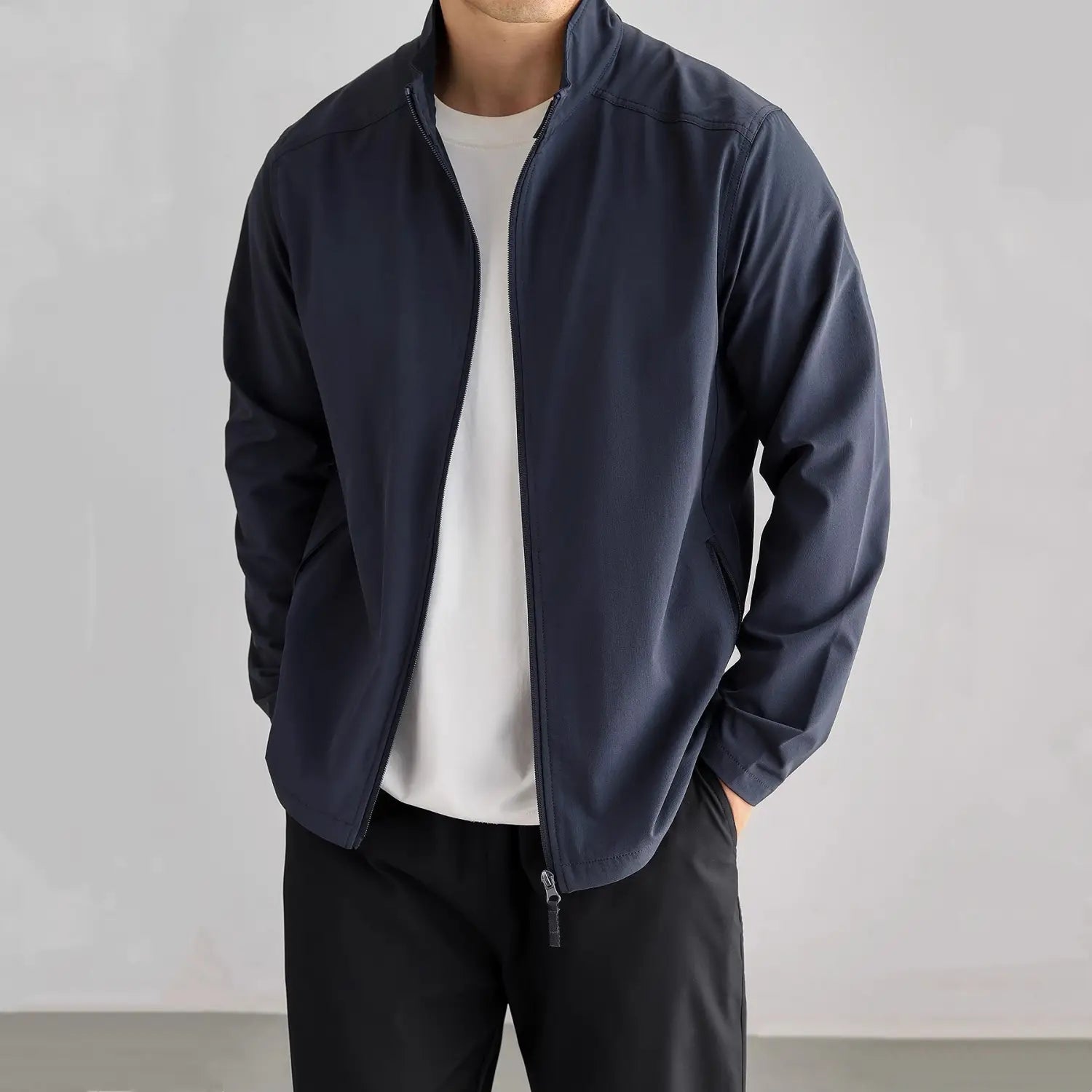 Veste bomber pour homme, tenue décontractée pour l’extérieur et le trajet quotidien, en tissu léger bleu marine, avec un design moderne épuré et des détails de surpiqûres subtils.