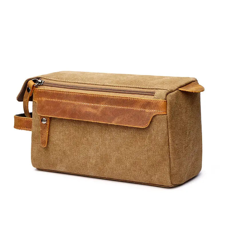 Tan canvas and leather large portable travel storage toiletry bag with a zippered top, front flap closure secured by a metal snap, and a sturdy handle.