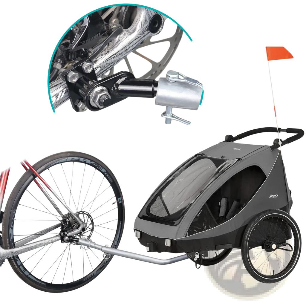 Gray and black child bike trailer with transparent front window attached to bicycle via silver metal hitch coupler adapter