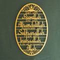 Gold-colored metal oval wall art with intricate cut-out designs and engraved islamic phrases key holder hook