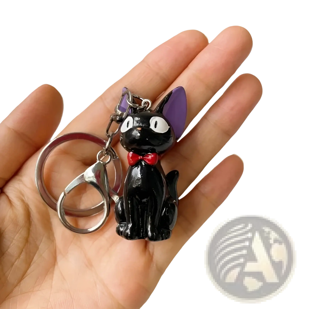 Black cat keychain with shiny enamel finish featuring purple ears and red bow made of pvc for bag charm use