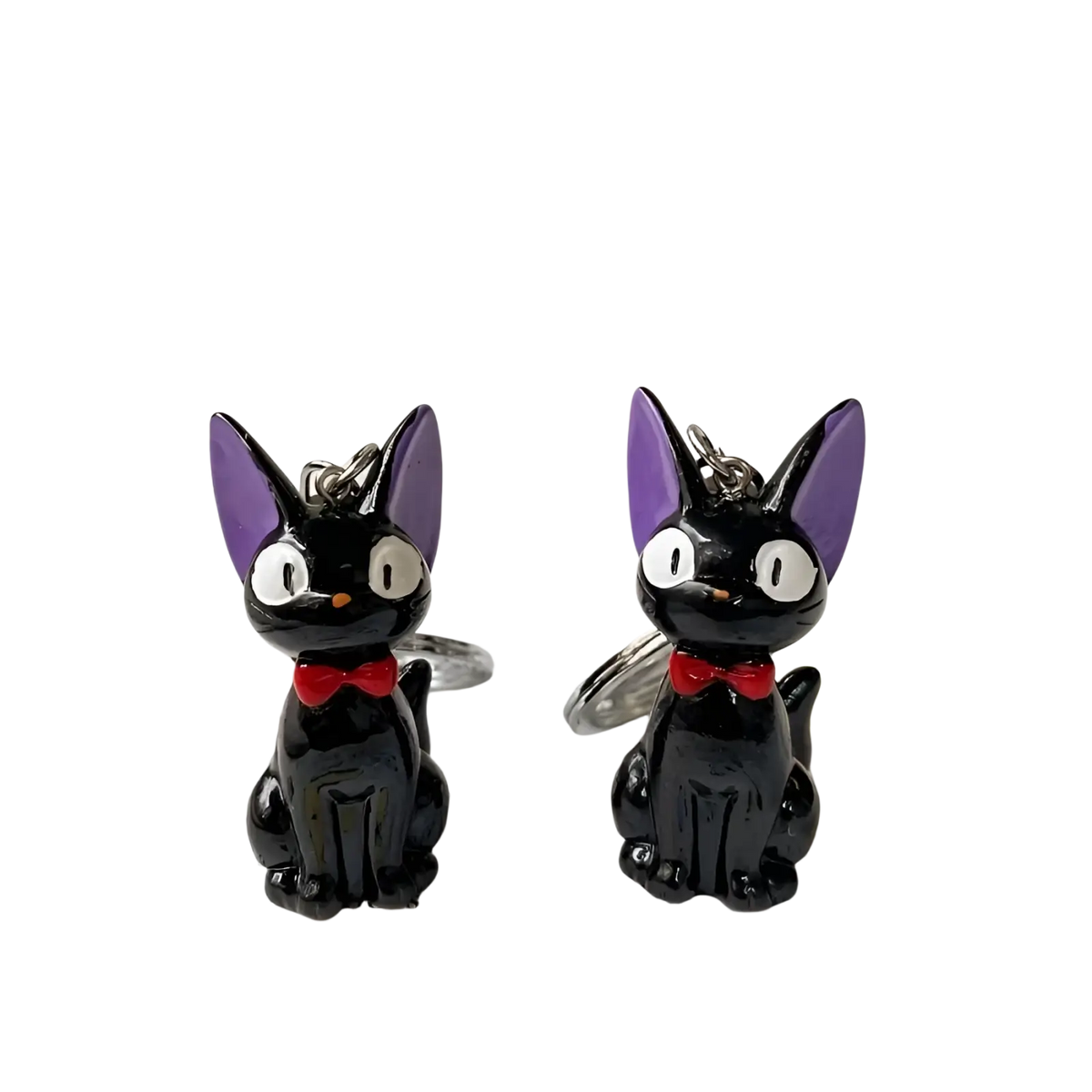 Two glossy black pvc cat keychains with purple ears red bow ties and silver metal rings for bags or keys