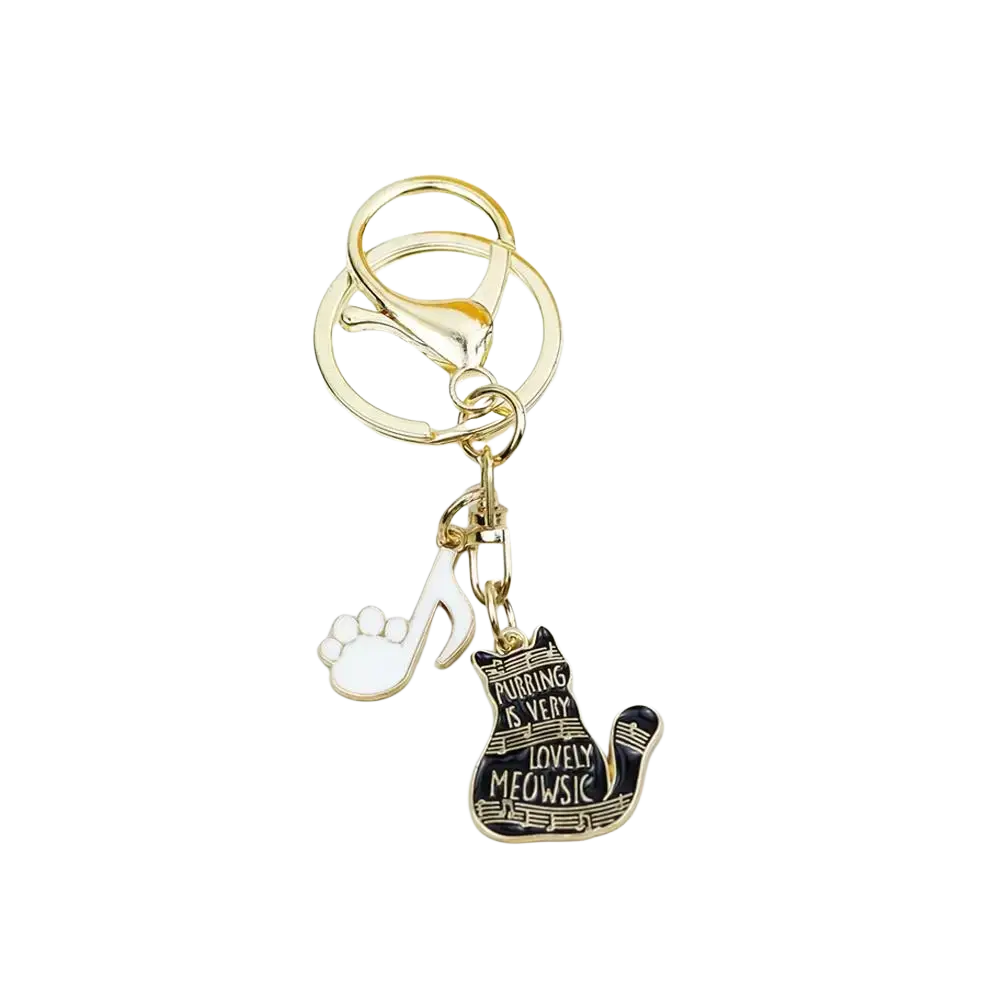 Gold-toned black cat piano keychain with enamel charm featuring purring is very lovely meowsic phrase and white paw print pendant