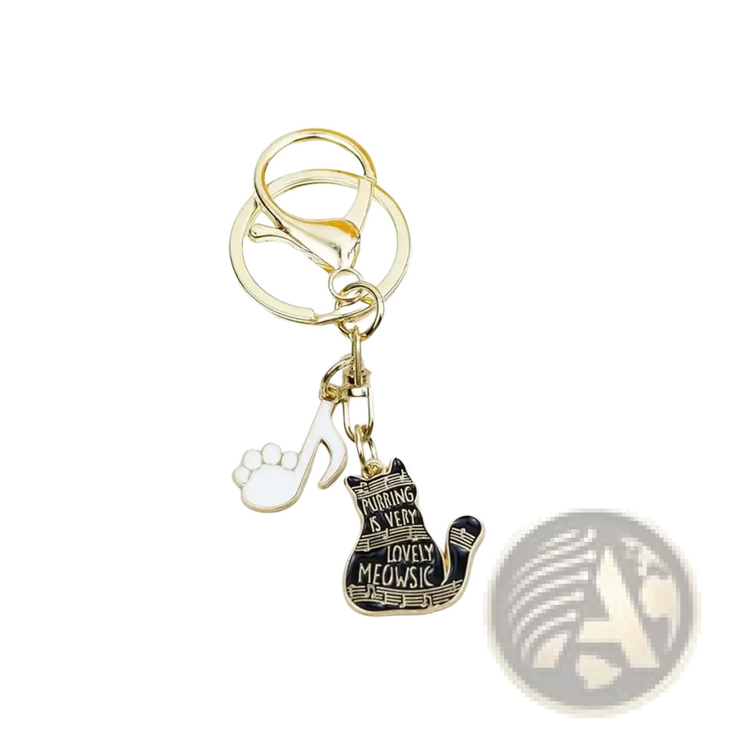 Gold-toned black cat piano keychain with enamel charm featuring purring is very lovely meowsic phrase and white paw print pendant