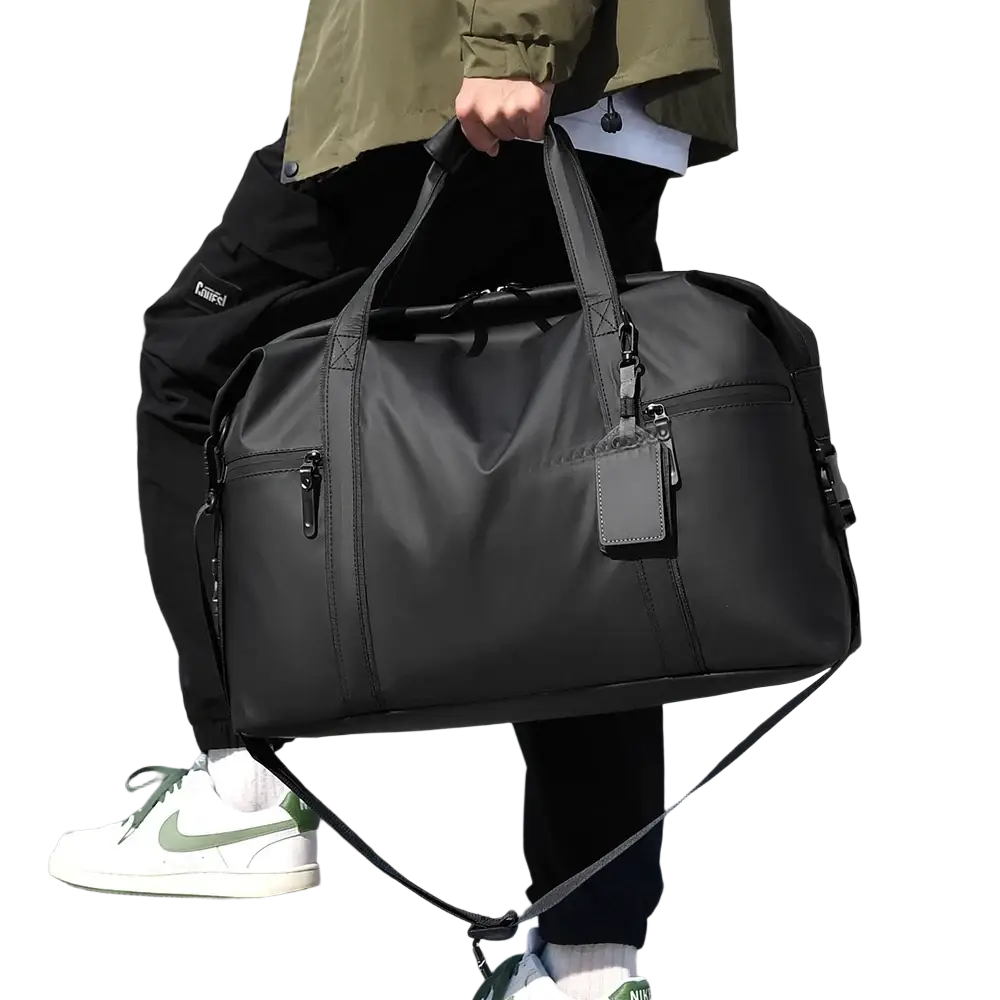Black gym duffel bag made of nylon with multiple zippers and detachable shoulder strap for travel and fitness gear