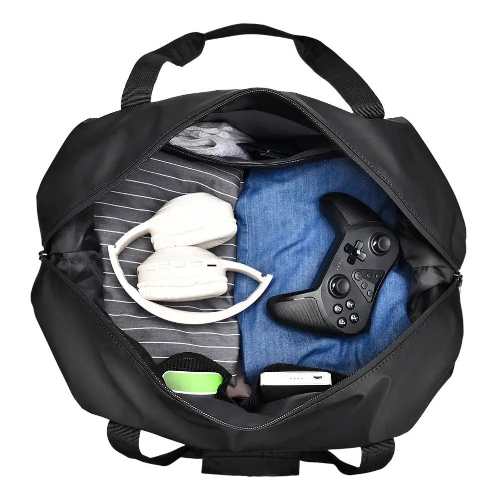 Black nylon gym duffel bag with dual top handles and front pocket filled with gaming gear including headphones and xbox controller