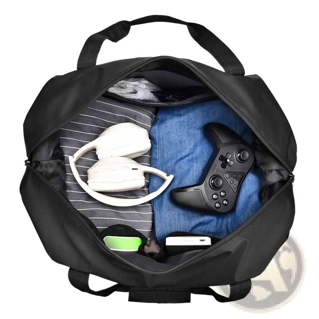 Black nylon gym duffel bag with dual top handles and front pocket filled with gaming gear including headphones and xbox controller
