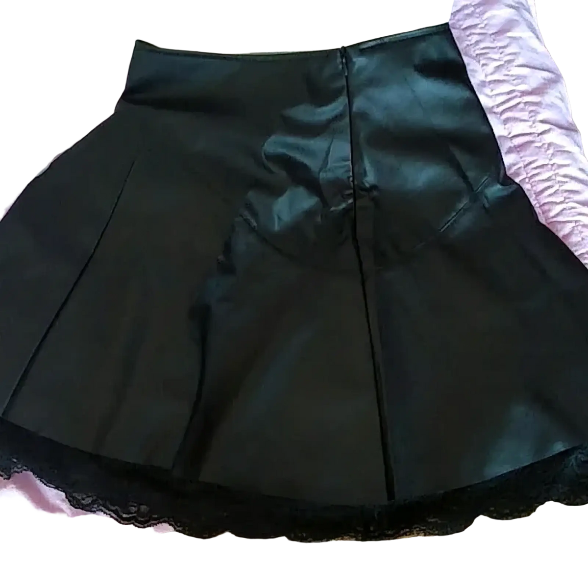 Black leather pleated skirt with shiny faux leather finish and delicate black lace trim along the hem