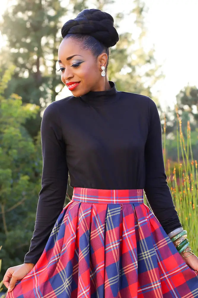 Vintage black long sleeve mock neck stretch top paired with a vibrant red and blue plaid pleated skirt with white accents