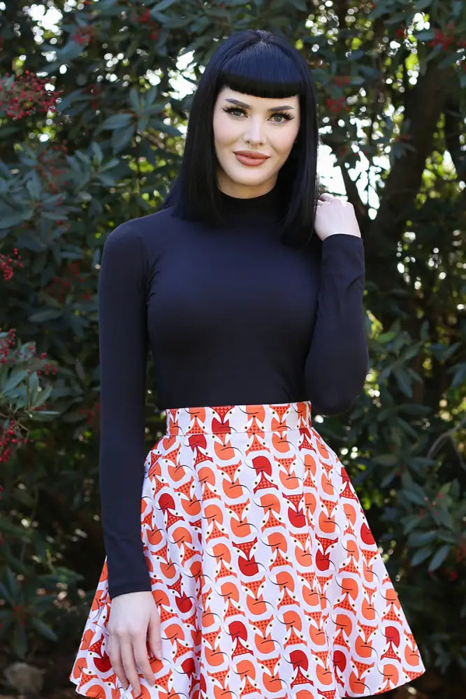 A flared skirt with white base and orange fox pattern paired with vintage black long sleeve mock neck stretch top