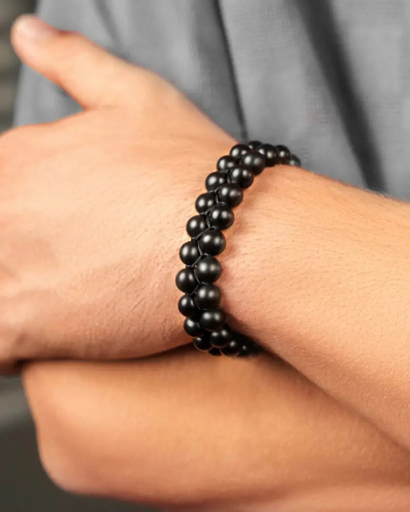 Morocco black obsidian beaded bracelet with adjustable cord worn on wrist showing black natural stones