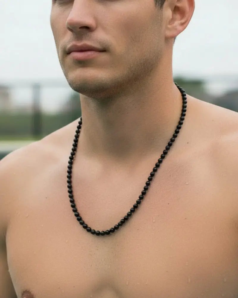 Black obsidian stainless steel beaded necklace featuring black beads worn around the neck