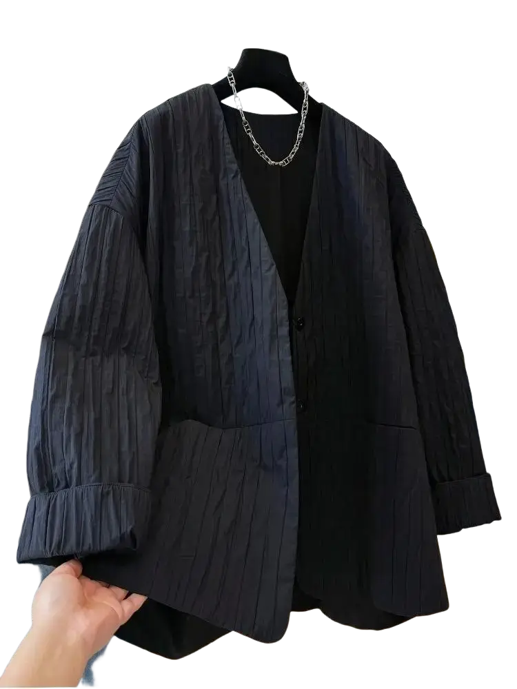 Black pleated blazer with relaxed fit and button closure paired with black quilted puffer winter parka jacket