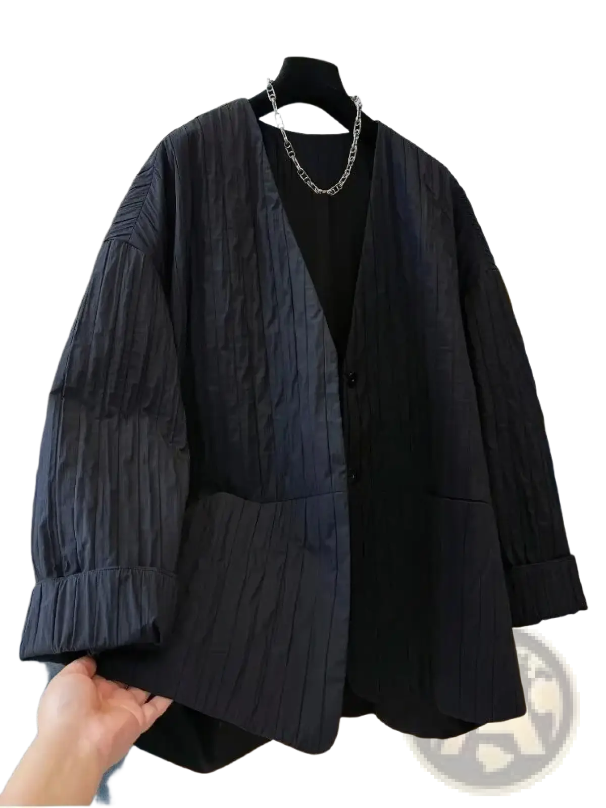 Black pleated blazer with relaxed fit and button closure paired with black quilted puffer winter parka jacket