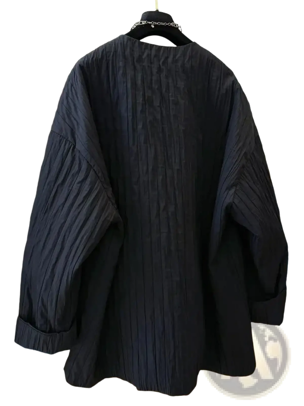 Black quilted puffer winter parka jacket with relaxed black pleated cotton blouse and rolled cuffs visible