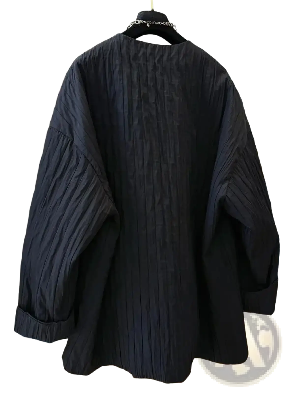 Black quilted puffer winter parka jacket with relaxed black pleated cotton blouse and rolled cuffs visible