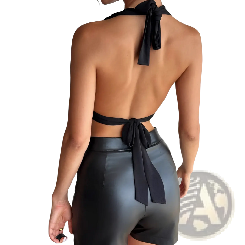 Black satin halter romper featuring a tie-back top and faux leather shorts shown from the back side