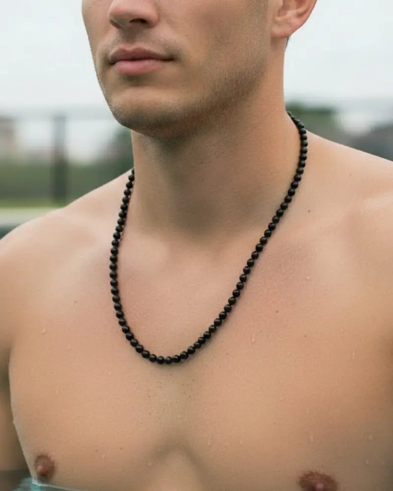 Black tourmaline beaded necklace in stainless steel worn around the neck showcasing its sleek design and durability