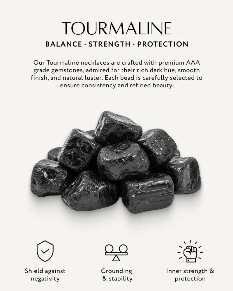 A pile of dark polished black tourmaline gemstones featured in a beaded necklace with stainless steel elements