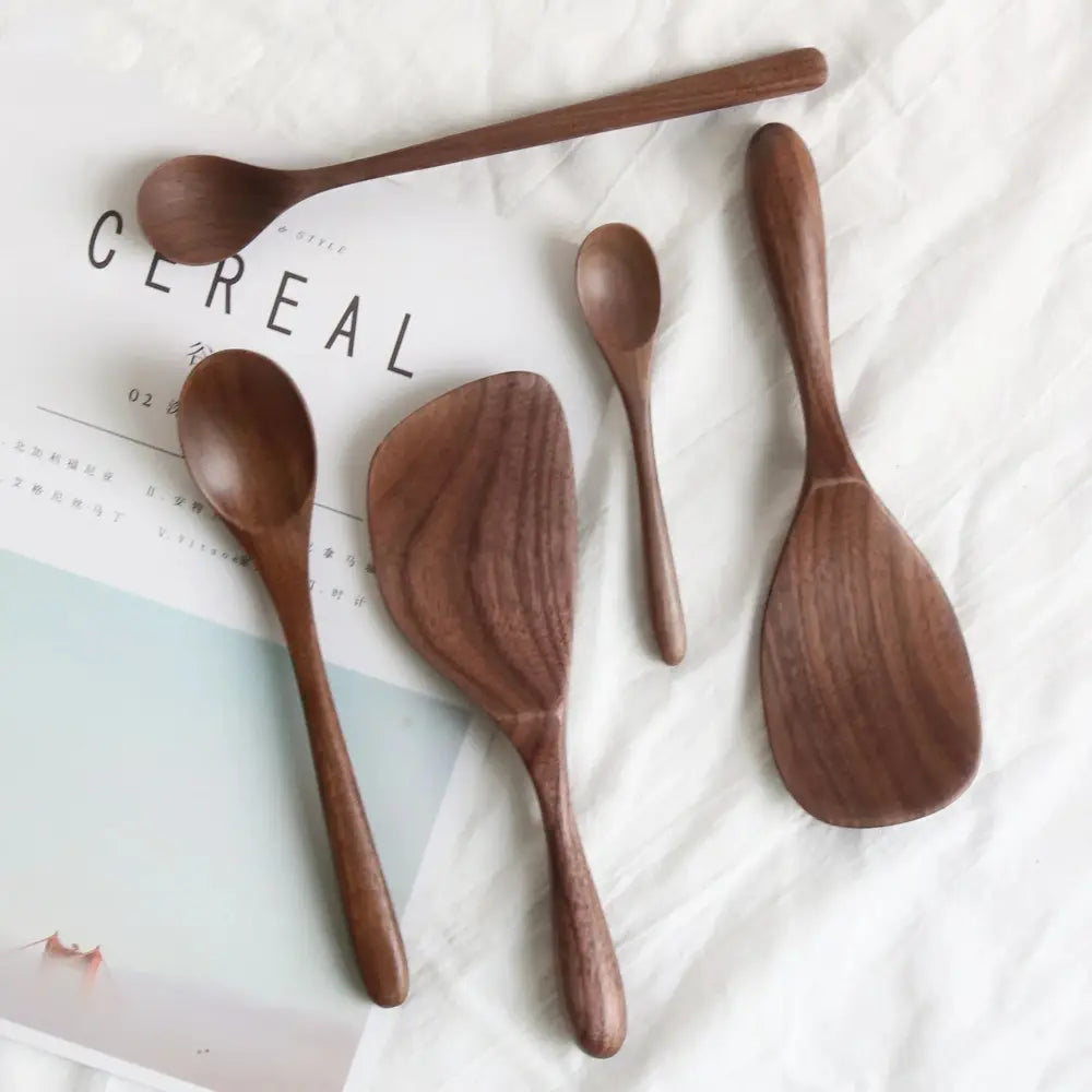 Set of five handcrafted black walnut wood dining spoons in warm brown tones with smooth natural wood grain finishes