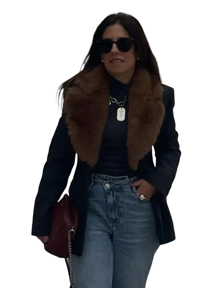 A burgundy leather handbag with a chain strap paired with a black wool coat with a fur collar