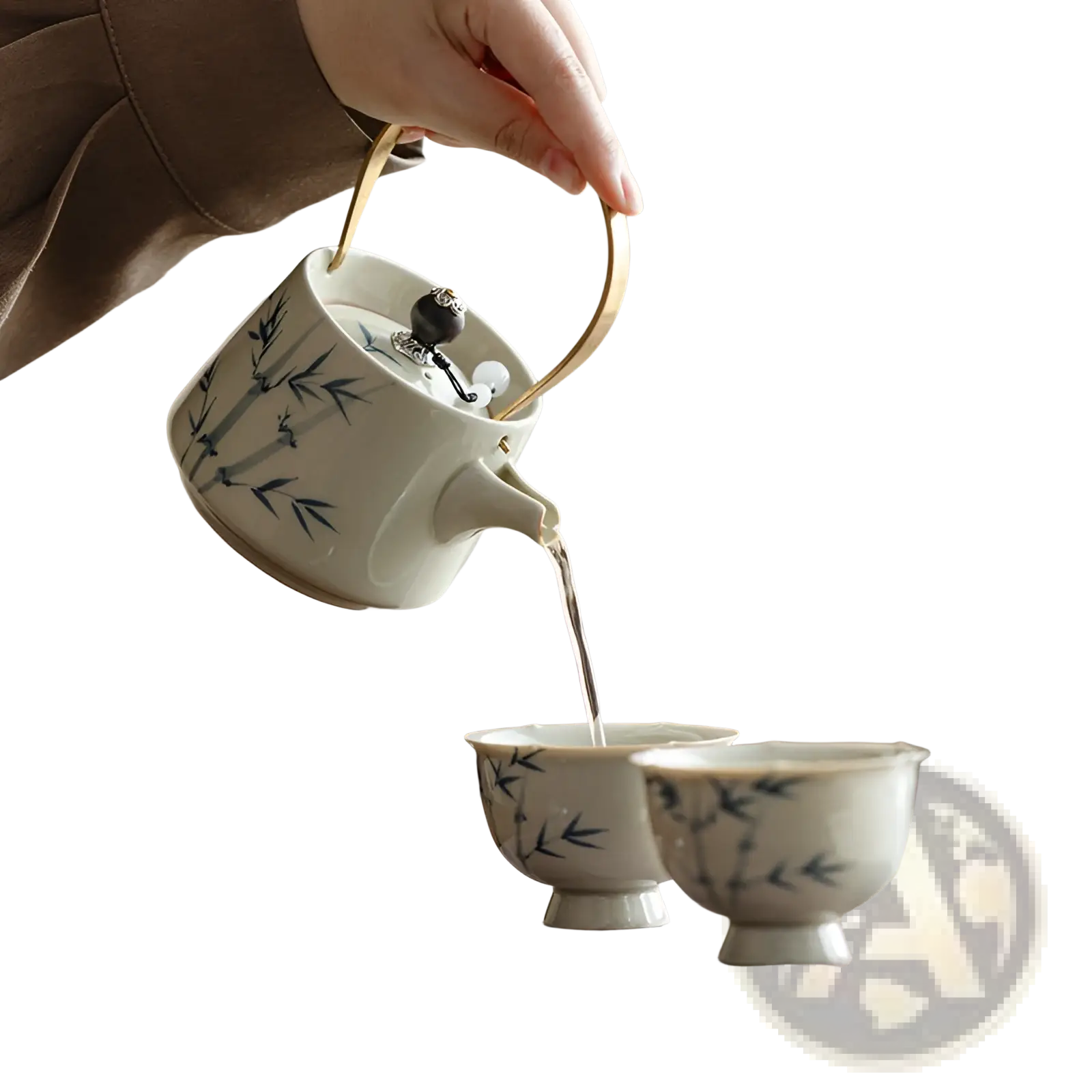 A white ceramic blue bamboo teapot set with polished gold handle being poured into matching cups