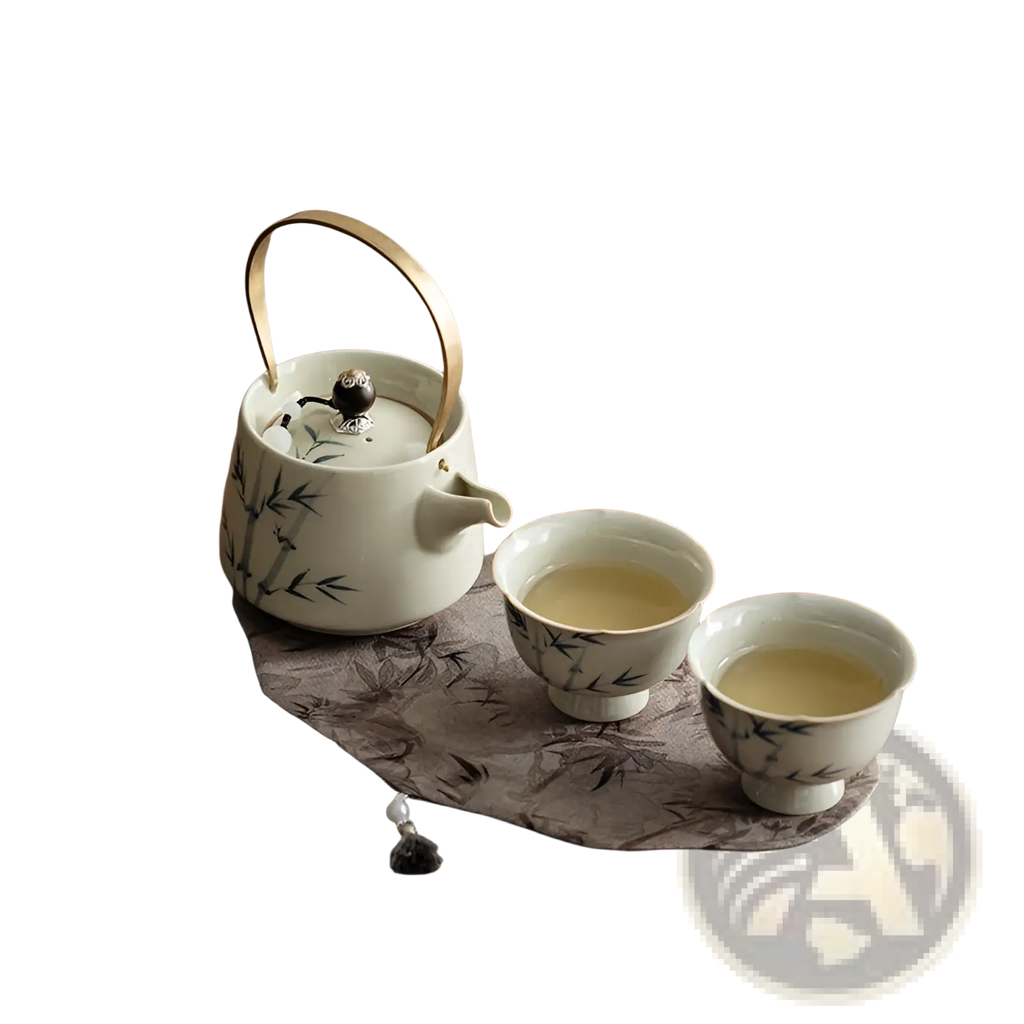 White ceramic blue bamboo teapot set with two cups featuring bamboo leaf design and gold-colored handle