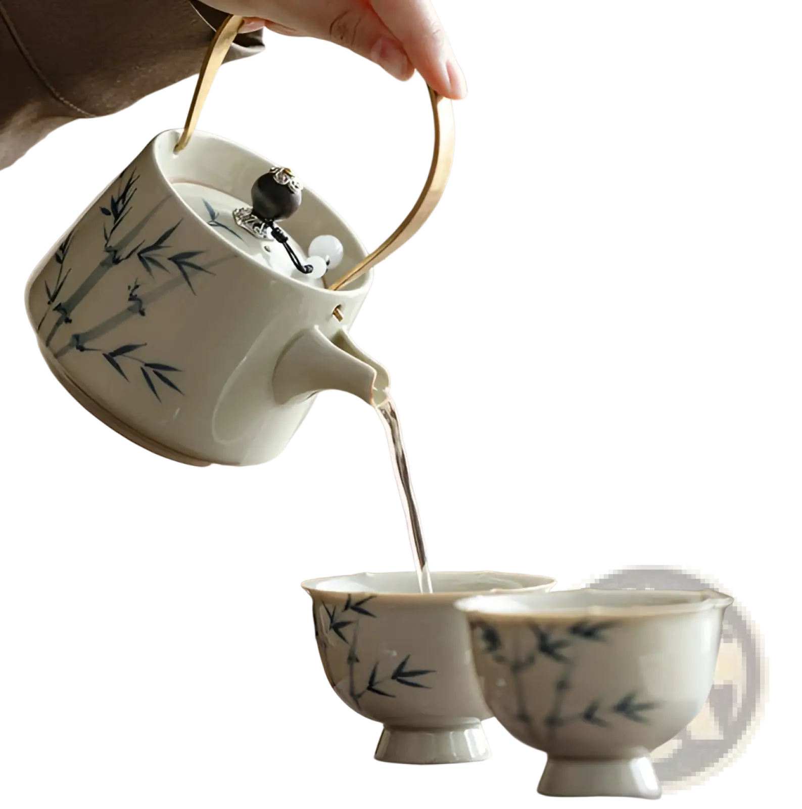 Blue bamboo ceramic teapot set with two cups pouring tea features white ceramic with blue bamboo design and gold handle