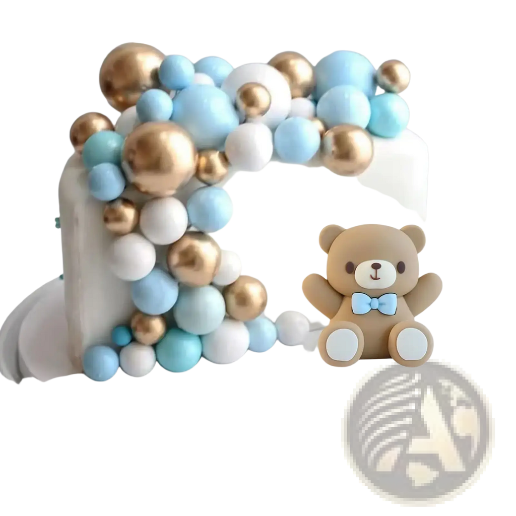 A white cake with blue bear cake topper set featuring light blue gold and white decorations for baby shower decor