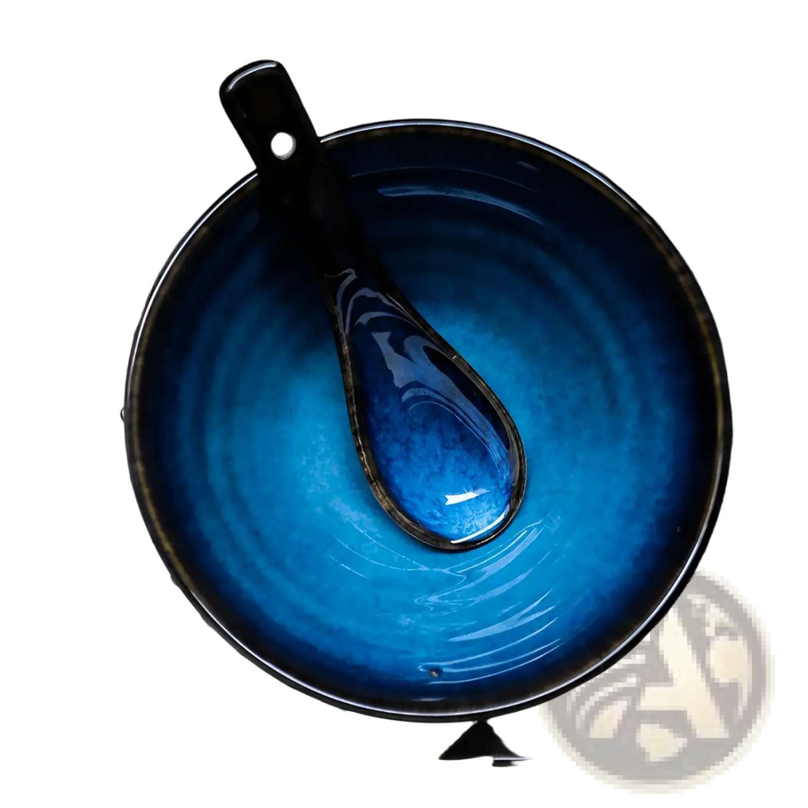 A vibrant blue ceramic spoon kiln glaze porcelain bowl with a glossy gradient and dark rim holding a matching spoon