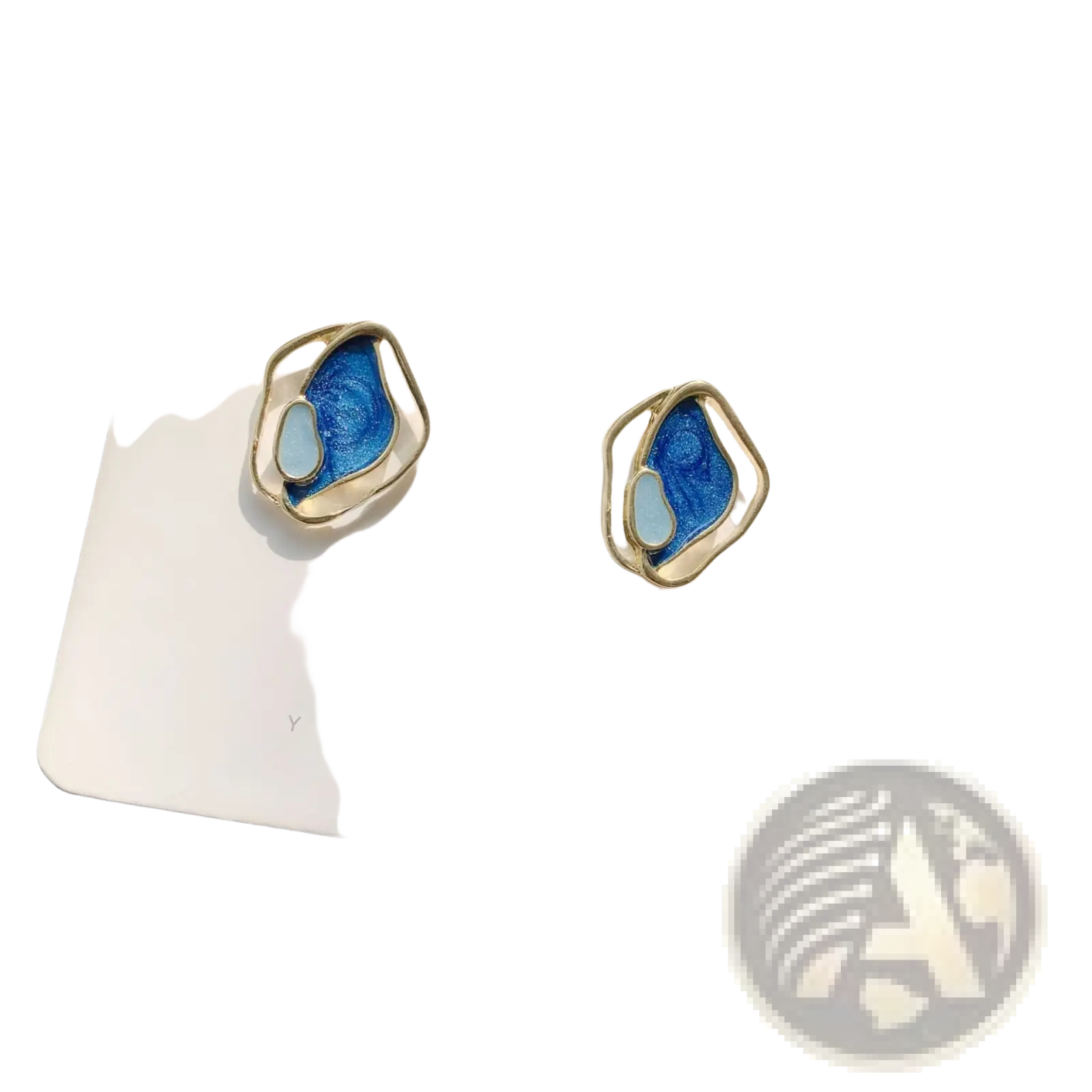 A pair of elegant blue enamel geometric silver stud earrings with gold-toned metal frames on a white card