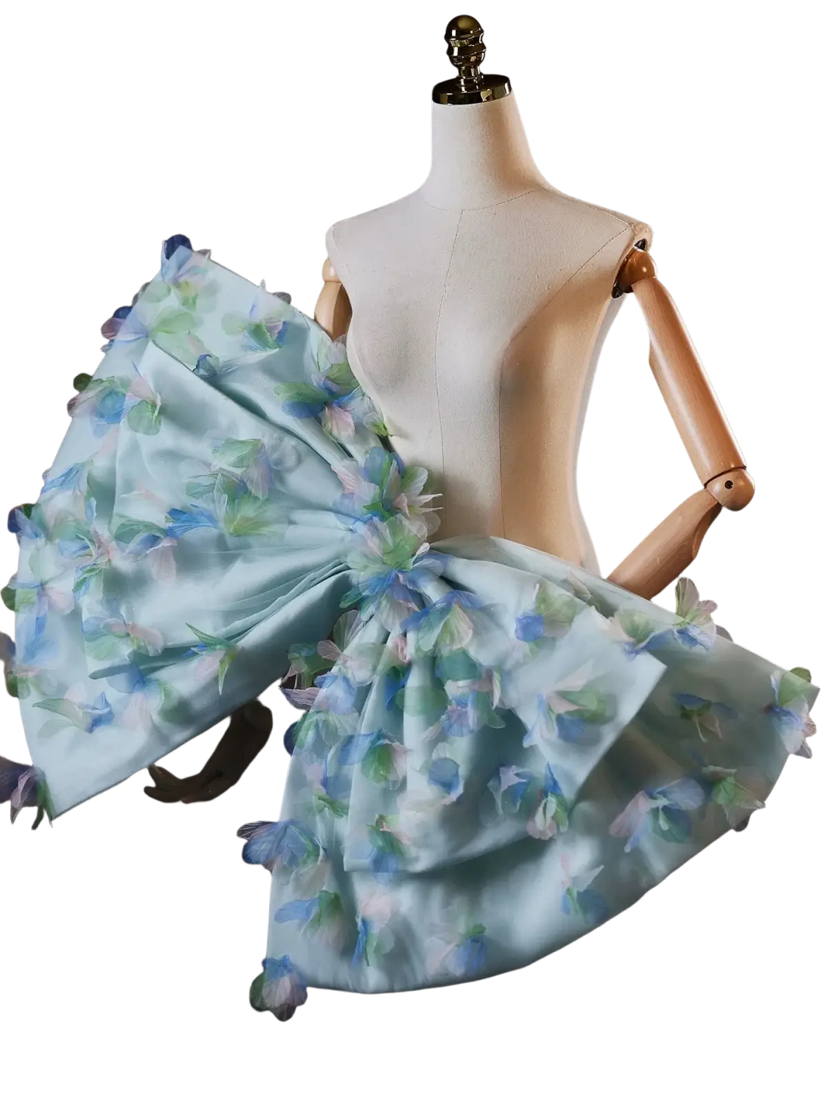 A delicate light blue floral bridal dress with a voluminous ruffled skirt and matching oversized bow at the shoulder