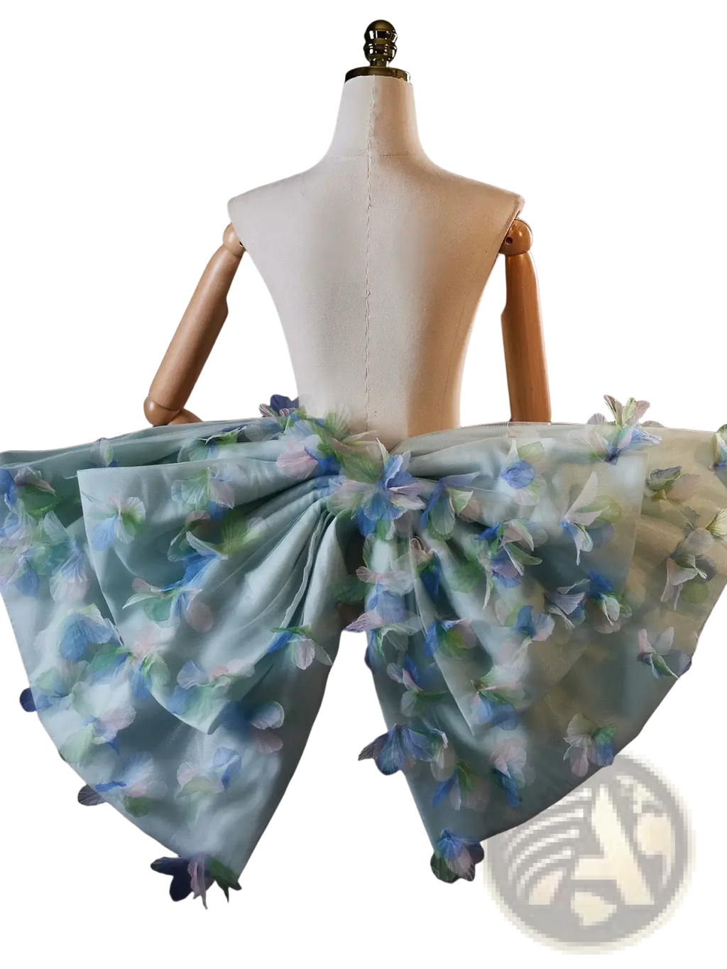 A delicate light blue floral bridal bow evening party skirt with sheer fabric and embroidered blossoms on a mannequin