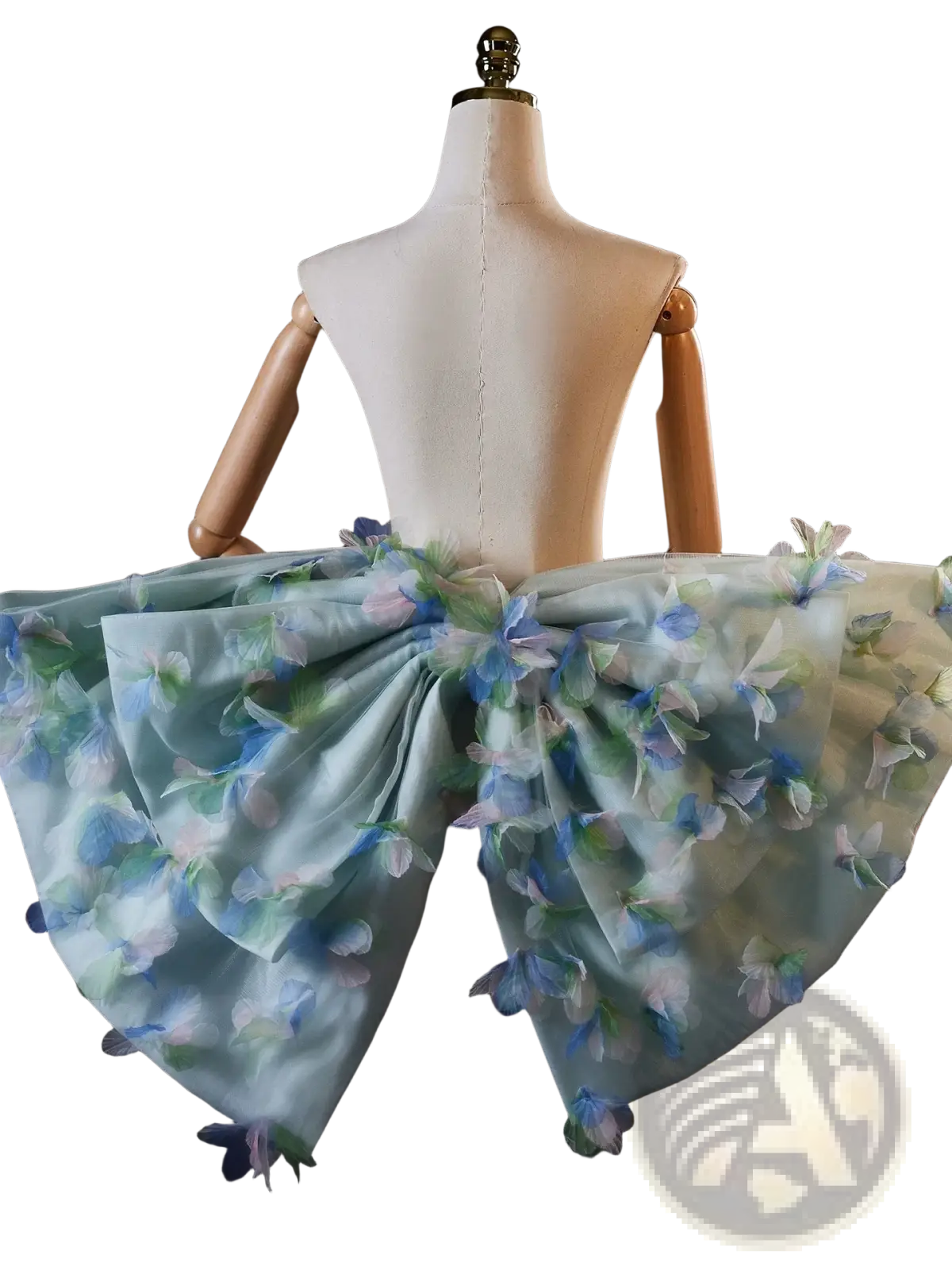 A delicate light blue floral bridal bow evening party skirt with sheer fabric and embroidered blossoms on a mannequin