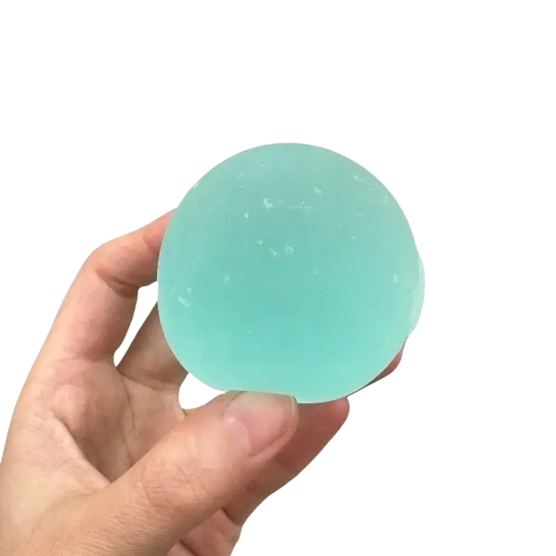 A translucent light blue mochi squeeze sensory fidget toy stress ball with a smooth slightly textured surface