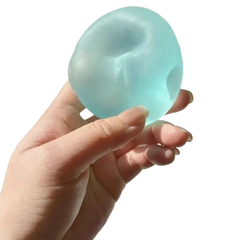 A translucent light blue mochi squeeze sensory fidget toy made of squishy material with a smooth textured surface