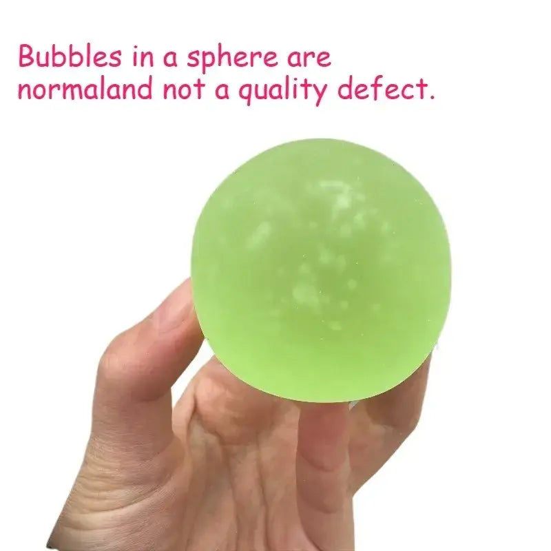 A translucent lime green blue mochi squeeze sensory fidget toy stress ball with small internal bubbles held in hand