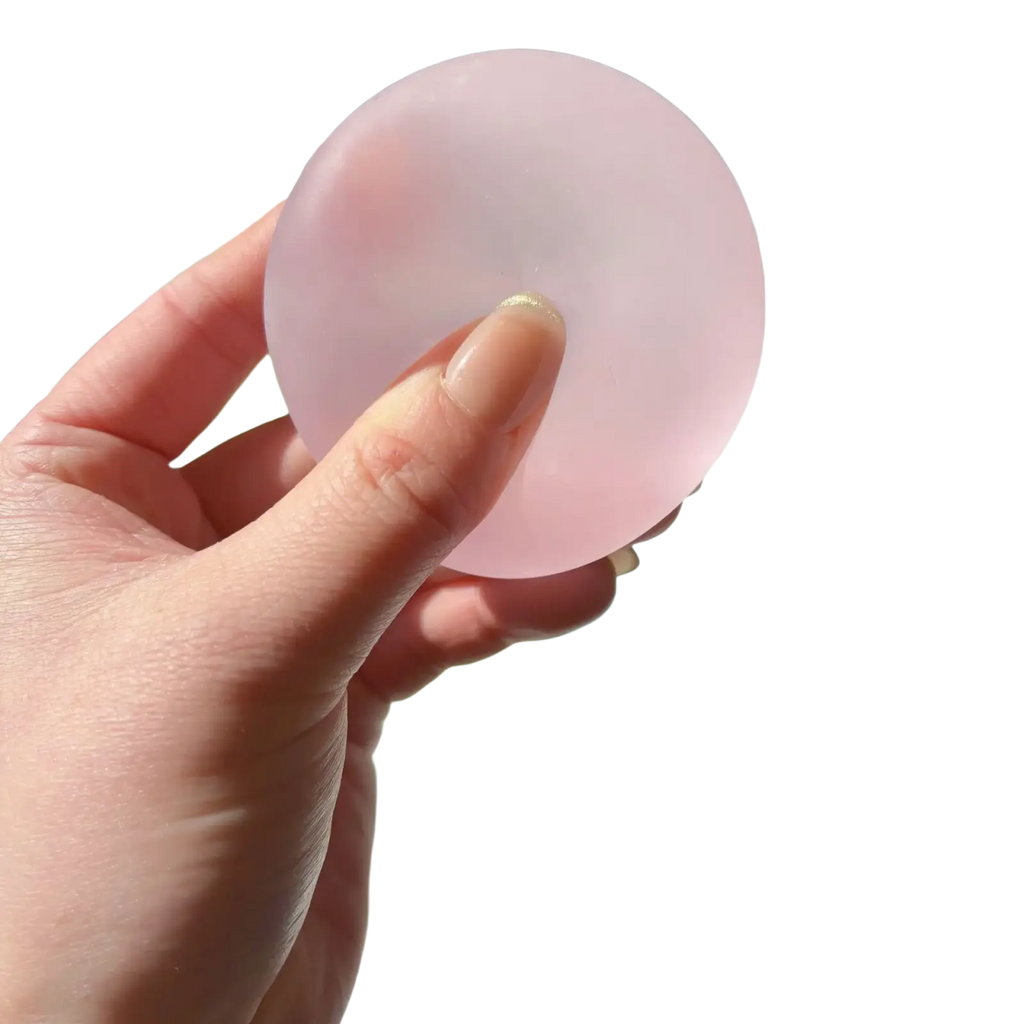 A translucent pink blue mochi squeeze sensory fidget toy held in hand designed for stress relief and tactile play