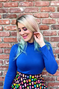 A vibrant royal blue vintage mock neck long sleeve top with a snug, form-fitting silhouette