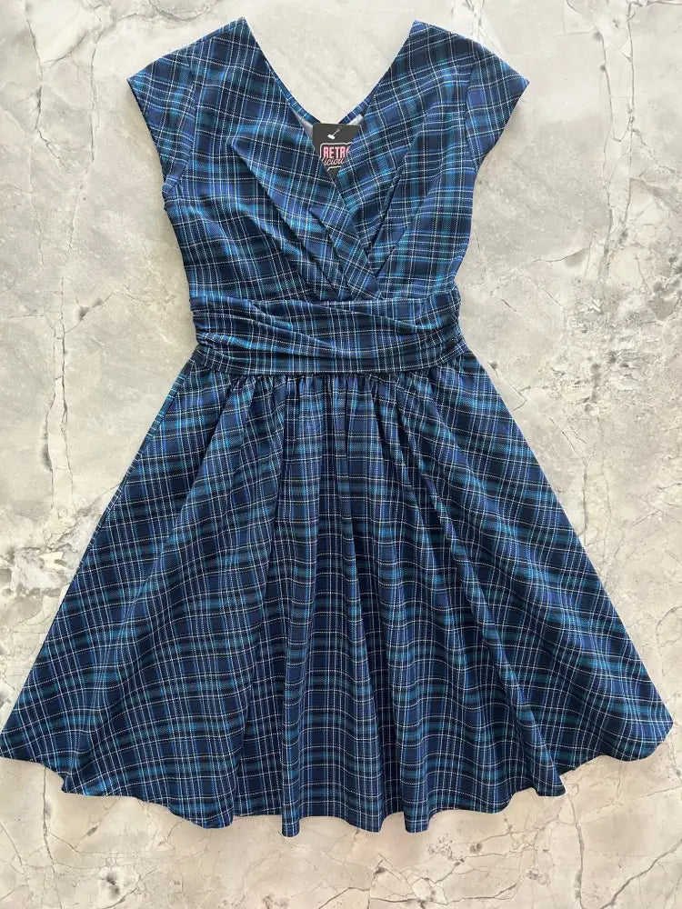 A navy blue and teal plaid cotton dress with v-neckline, short sleeves, gathered waist, and pockets