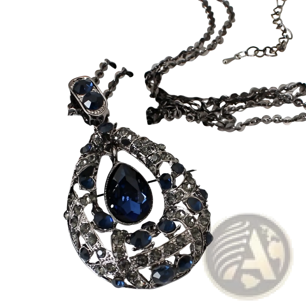An ornate dark blue teardrop pendant necklace with a silver-toned filigree frame and crystal embellishments