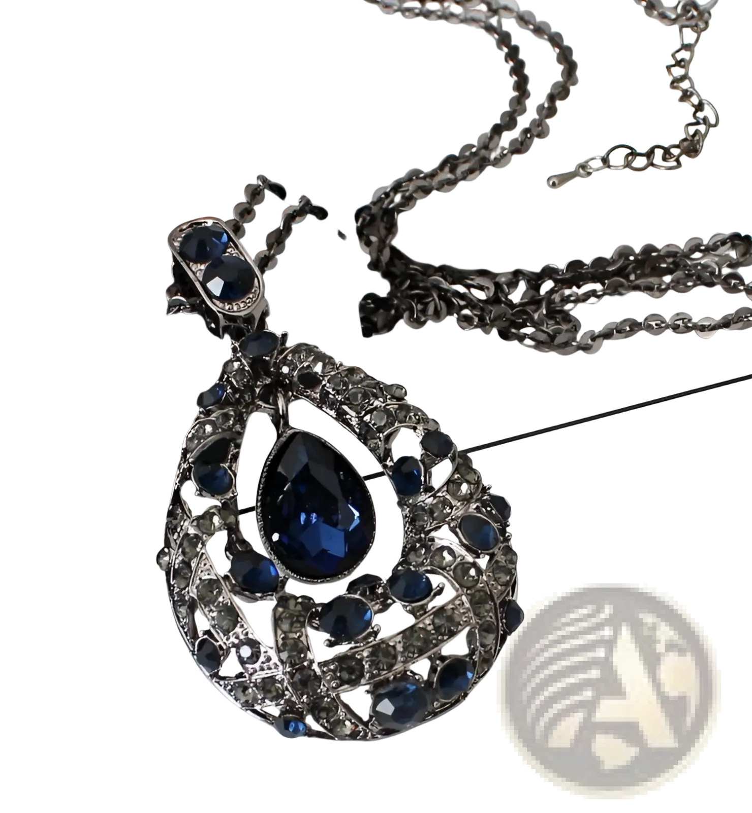 Elegant dark blue teardrop pendant necklace with intricate silver-toned filigree and sparkling gemstones on a sweater chain