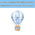 A charming blue teddy bear baby shower cutout centerpiece featuring a light blue and white striped hot air balloon with lace bows