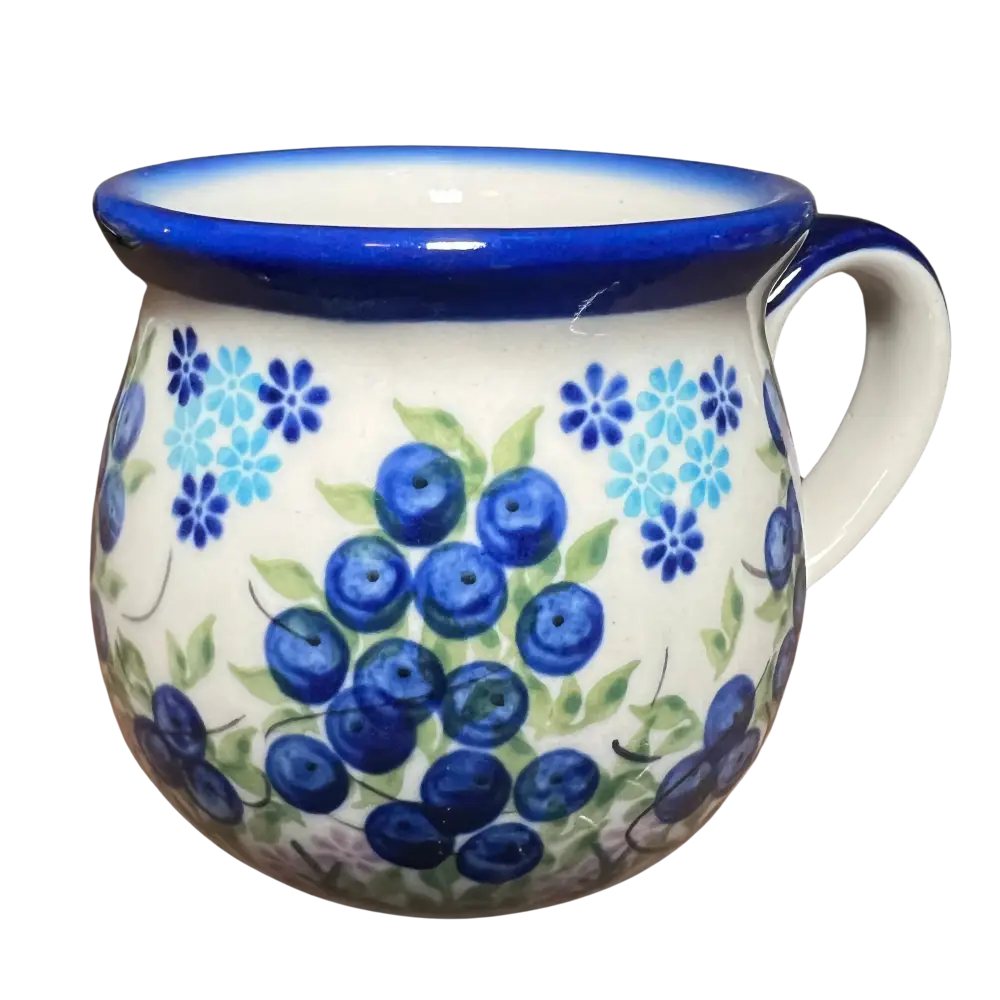 A white ceramic fermentation and pickling mug with blue rim and handle hand-painted with blueberries and flowers