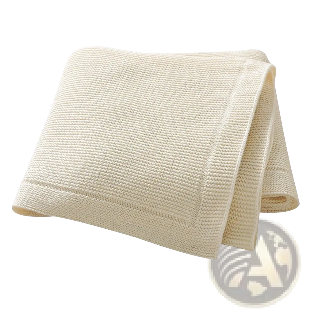Cream-colored waffle-weave towel with soft texture and finished edges paired with blush pink knitted cotton baby blanket