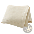 Cream-colored waffle-weave towel with soft texture and finished edges paired with blush pink knitted cotton baby blanket