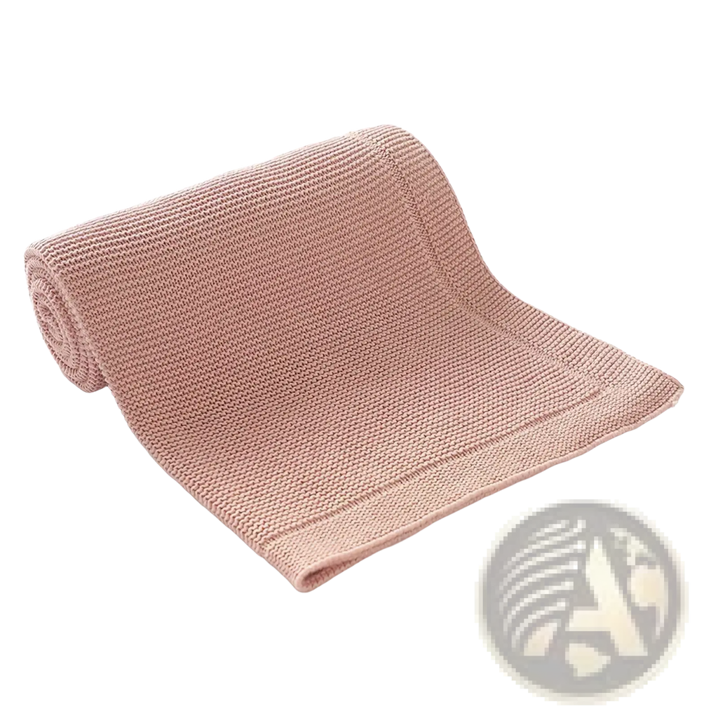 A blush pink knitted baby blanket made of cotton featuring a soft textured ribbed pattern for receiving use