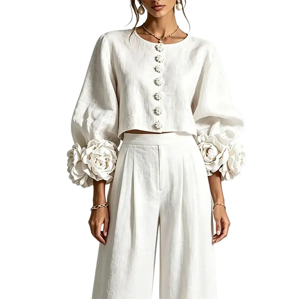 White linen crop top with puff sleeves and floral embellishments at cuffs paired with blush pink linen wide leg pants two piece set closure type not shown
