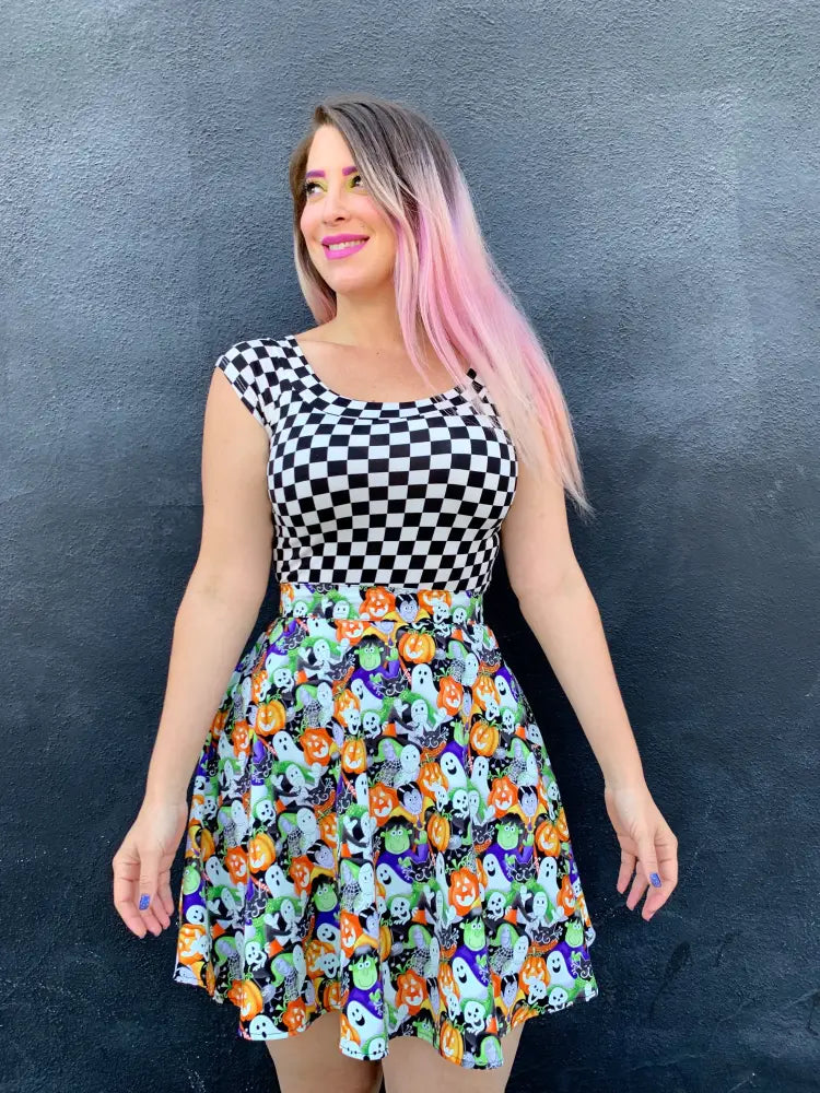 Vintage 1950s black and white checkered boat neck dress with a festive skirt featuring pumpkins ghosts and skulls